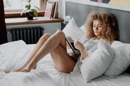 en kvinna läser i sängen