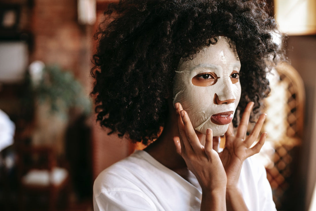 en kvinna med en sheetmask i ansiktet för att behandla torr och känslig hud