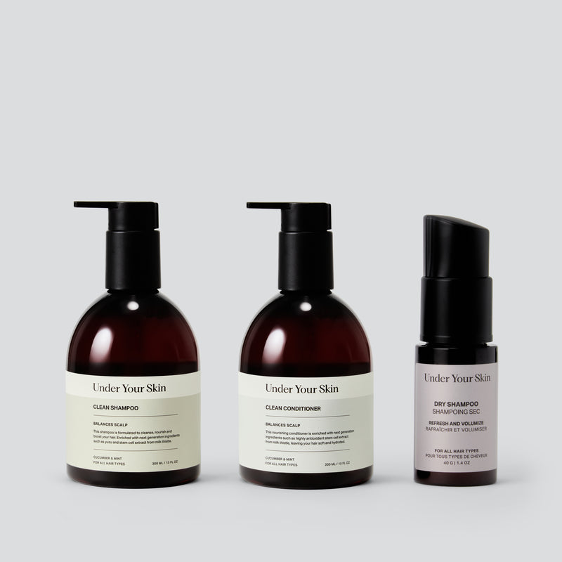 Under Your Skin Detoxing Shampoo, Hydrating Conditioner, and Powder Dry Shampoo. The shampoo and conditioner come in 300ml/10 oz brown bottles with pumps. The dry shampoo is a 40g/1.4 oz brown bottle with a pump dispenser. This three-step routine is designed to clarify, hydrate, and refresh roots between washes.