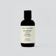 En ensam flaska av Under Your Skin Clean Conditioner står mot vit bakgrund. Etiketten visar att balsamet är veganskt och detoxar hårbotten.